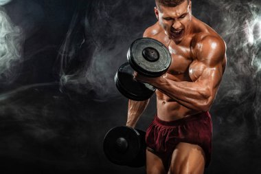 Acımasız güçlü kas vücut geliştirmeci atletik erkek siyah arka plan üzerine dumbbell ile kasları kadar pompalama. Egzersiz vücut geliştirme kavramı. Spor beslenme reklamlar için kopya alanı.