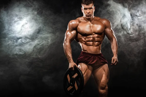 Βάναυση ισχυρή μυϊκή bodybuilder Αθλητικός άνδρας άντληση τους μυς με barbell σε μαύρο φόντο. Προπόνηση bodybuilding έννοια. Χώρο αντίγραφο για Αθλητισμός διατροφή διαφημίσεις. — Φωτογραφία Αρχείου