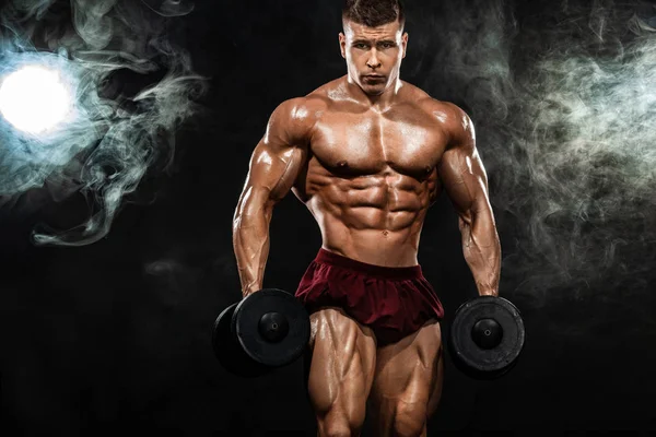 Brutal stærk muskuløs bodybuilder atletisk mand pumpe op muskler med håndvægt på sort baggrund. Træning bodybuilding koncept. Kopier plads til sport ernæring annoncer . - Stock-foto