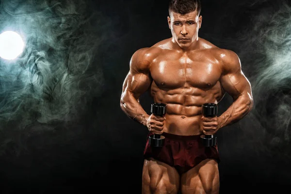 Brutaler kräftiger muskulöser Bodybuilder athletischer Mann, der mit einer Hantel auf schwarzem Hintergrund Muskeln aufpumpt. Workout Bodybuilding Konzept. Kopierraum für Sporternährungsanzeigen. — Stockfoto