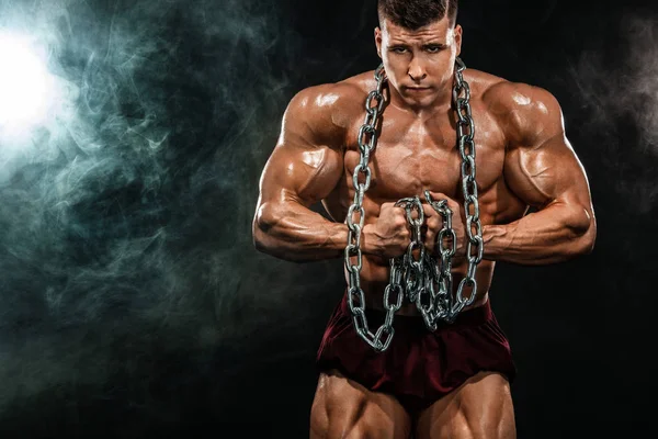 Acımasız güçlü kas vücut geliştirmeci atletik bir adam kas zincirleri siyah arka plan üzerine kadar pompalama. Egzersiz vücut geliştirme kavramı. Spor beslenme reklamlar için kopya alanı. — Stok fotoğraf