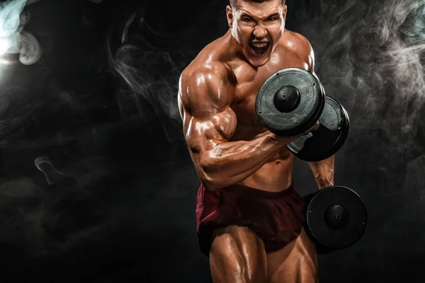 Brutal forte musculoso homem atlético fisiculturista bombeando os músculos com halteres no fundo preto. Conceito de musculação treino. Espaço de cópia para anúncios de nutrição esportiva . — Fotografia de Stock