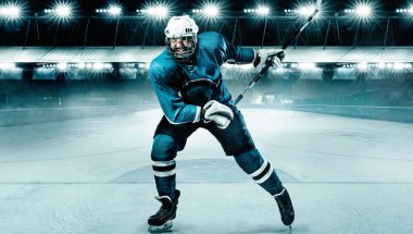 Kasklı buz hokeyi oyuncusu atlet ve stadyumda sopayla eldiven. Aksiyon atışı. Spor konsepti.