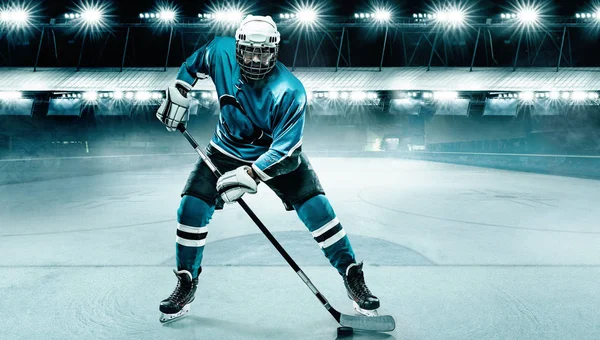 Giocatore di hockey su ghiaccio atleta nel casco e guanti sullo stadio con bastone. Un colpo d'azione. Concetto sportivo. — Foto Stock