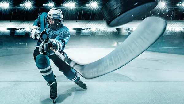 Χόκεϊ επί πάγου αθλητής στο κράνος και γάντια στο γήπεδο με ραβδί. Πυροβολισμός δράσης. Αθλητική έννοια. Εικόνα Αρχείου