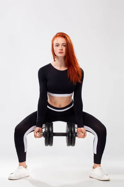 Deportiva mujer en forma, atleta con mancuernas hace ejercicio de fitness sobre fondo blanco . — Foto de Stock