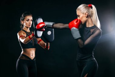 İki kadın trainging mücadele siyah arka plan üzerine önce atlet ve boxer. Spor ve boks konsepti.