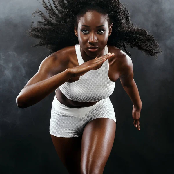 Сильная атлетическая черная кожаная женщина-спринтер, бегущая на заднем плане с дымом в спортивной одежде. Фитнес и спортивная мотивация. Концепция бегуна с местом для копирования . — стоковое фото