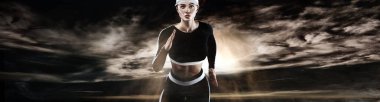 Güçlü atletik kadın sprinter, spor içinde giyen koyu arka plan üzerinde çalışan. Fitness ve spor motivasyon. Runner kavramı.