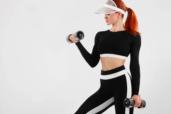 Deportiva mujer en forma, atleta con mancuernas hace ejercicio de fitness sobre fondo blanco . — Foto de Stock