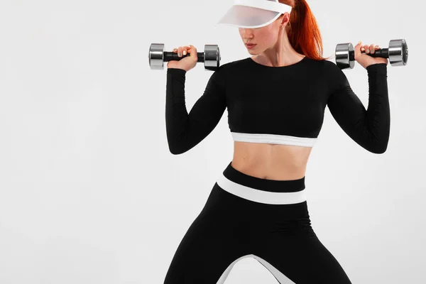 Donna in forma sportiva, atleta con manubri fa esercizio di fitness su sfondo bianco . — Foto Stock
