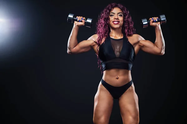 Sporty fit woman, athlete, egyptian and muslim with dumbbells makes fitness exercising on black background with lights. — 스톡 사진
