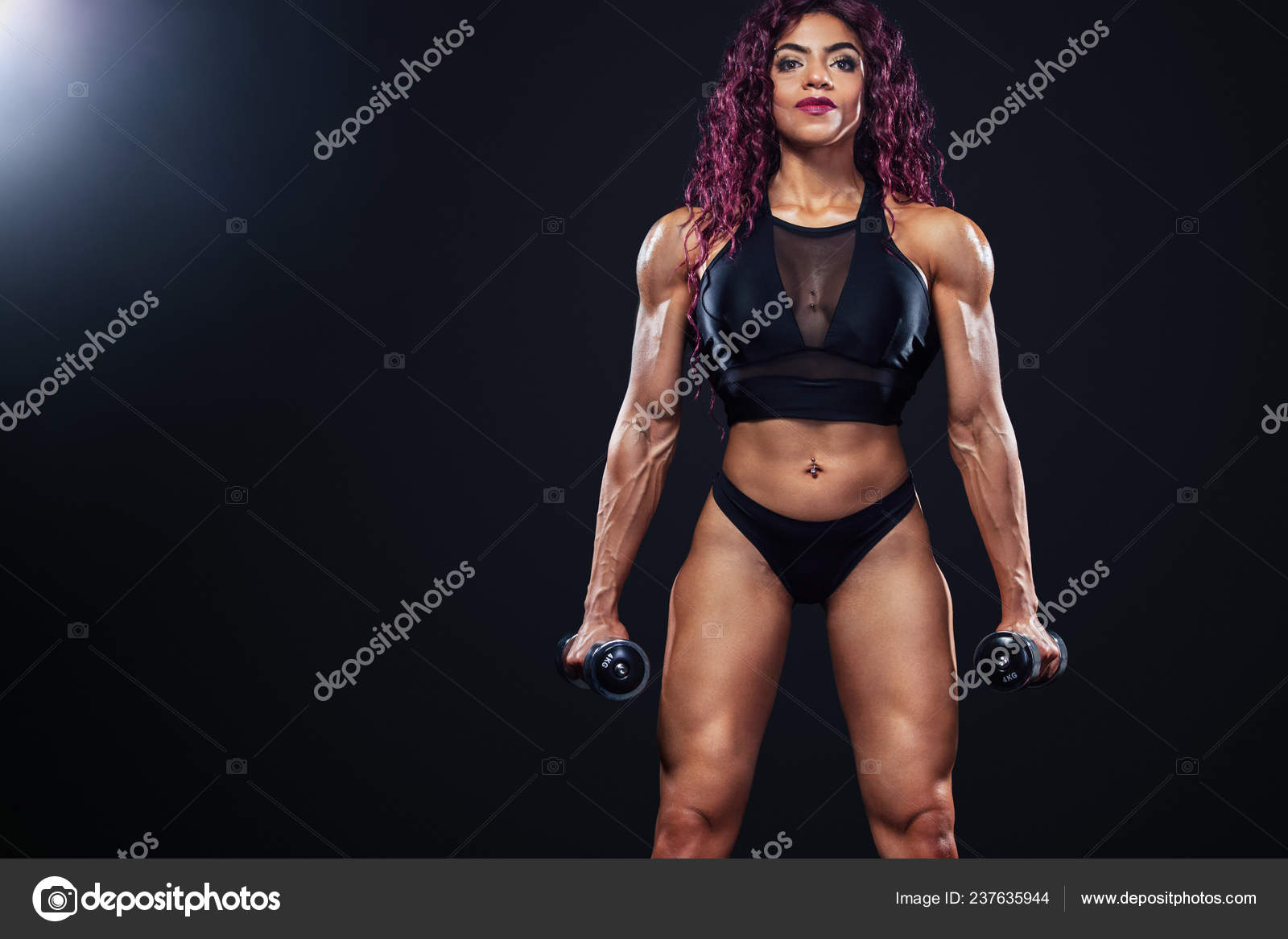 Sporty fit woman, athlete, egyptian and muslim with dumbbells makes fitness  exercising on black background with lights. Stock Photo by ©MikeOrlov  237635944