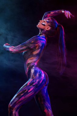 Genç kadın farklı renklerde boyanmış. Müzik ilham dansa. Bodyart renkli. Sanat moda makyaj ile muhteşem bir kadın.