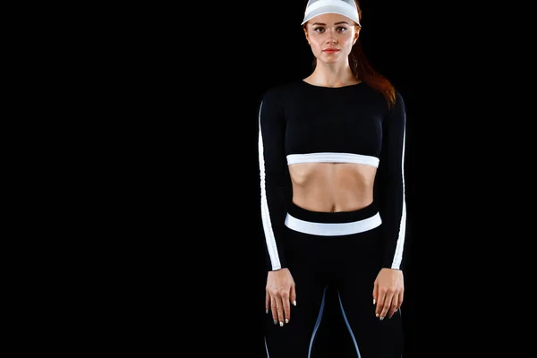 Forte donna atletica, posa su sfondo nero indossando in abbigliamento sportivo. Energia fitness e motivazione sportiva. Copia spazio . — Foto Stock