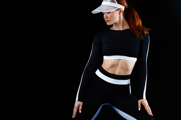 Mujer atlética fuerte, posando sobre fondo negro usando ropa deportiva. Aptitud energética y motivación deportiva. Copiar espacio . — Foto de Stock