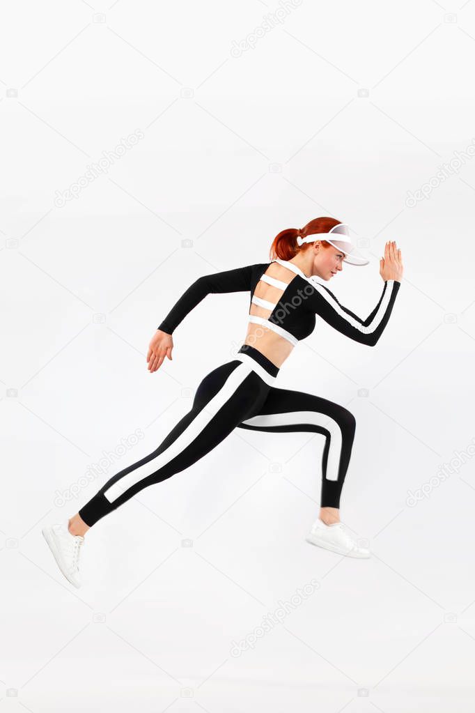 Strong athletic woman sprinter, running on white background wearing sportswears. Fitness and sport motivation. Runner concept with copy space.