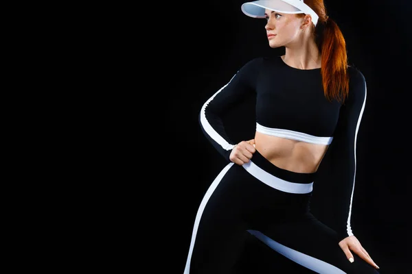Sterke atletische vrouw, die zich voordeed op zwarte achtergrond dragen in sportkleding. Energie fitness en sport motivatie. Kopiëren van ruimte. — Stockfoto