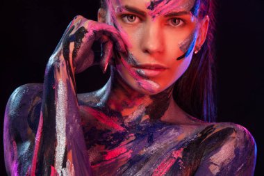 Genç kadın farklı renklerde boyanmış. Müzik ilham dansa. Vücut sanatı renkli. Sanat moda makyaj ve bodyart ile muhteşem bir kadın.