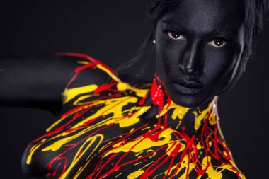 Sanat moda makyaj ile neşeli genç kadın. Siyah, sarı ve kırmızı boya makyaj ile muhteşem bir kadın
