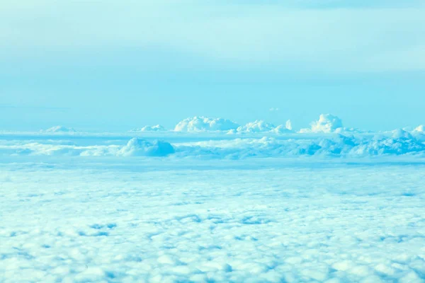 Flugzeug fliegt in den blauen Himmel zwischen weißen Wolken — Stockfoto