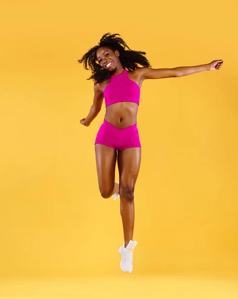 Mulher de pele preta ajuste desportivo, atleta faz exercício de fitness no fundo escuro . — Fotografia de Stock