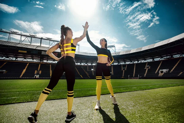 Zwei athletisch sportliche Frauen aus einem Team in Sportbekleidung mit Fußballball auf dem Stadion. — Stockfoto