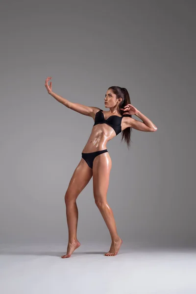 Fitness dançarina e mulher modelo de moda em biquíni. Mulher com pele molhada em lingerie posando em estúdio . — Fotografia de Stock