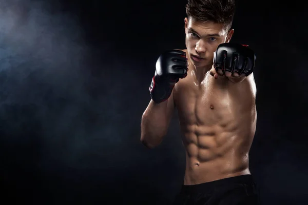 Sportsman boxer fighting on black background with smoke. Copy Space. Boxing sport concept.