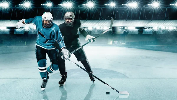 Arena de hóquei no gelo. Dois jogadores competem no capacete e luvas no estádio com pau e disco . — Fotografia de Stock