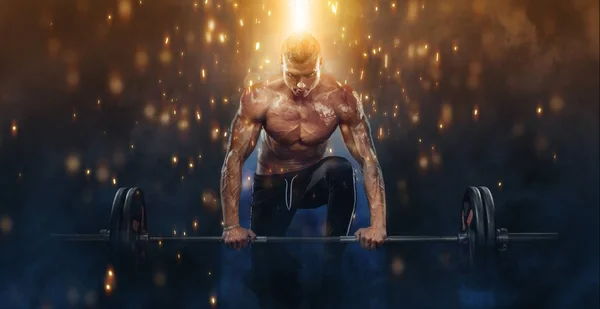 Foto de fuerte musculoso culturista atlético hombre bombeando los músculos con la barra en el fondo de fuego. Concepto de culturismo de energía de entrenamiento . — Foto de Stock