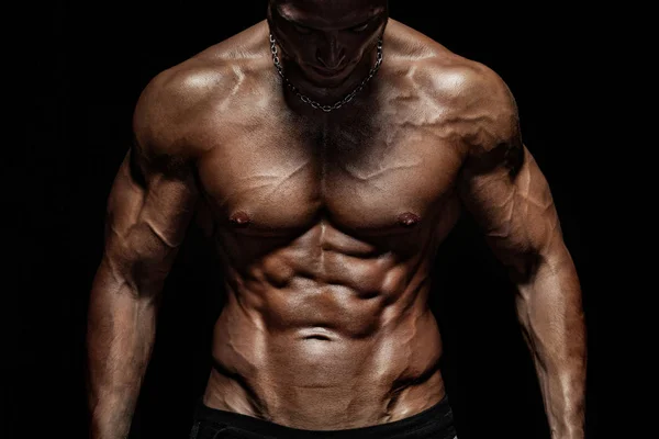 Bodybuilding wedstrijden op de scène. Man sporters lichaamsbouw en atleet. Zwarte achtergrond. — Stockfoto