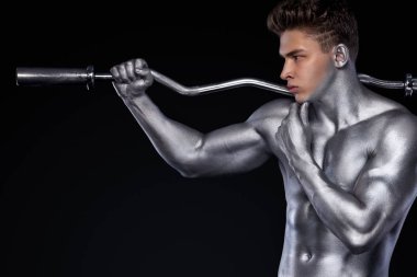Acımasız güçlü kas vücut geliştirmeci atletik erkek siyah arka plan üzerinde halter ile kasları kadar pompalama. Egzersiz vücut geliştirme kavramı. Spor beslenme reklamlar için kopya alanı.