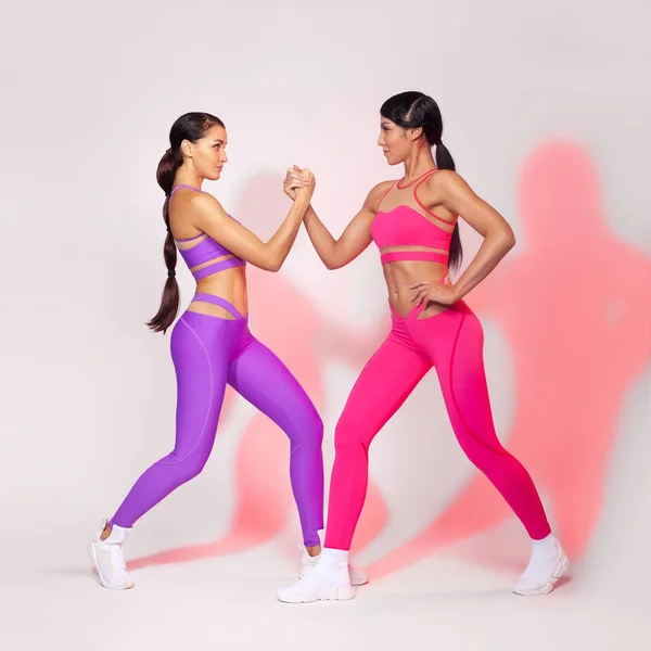 Mujer atlética fuerte, haciendo ejercicio sobre fondo blanco usando ropa deportiva. Fitness y motivación deportiva . — Foto de Stock