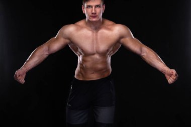 Vücut geliştirme yarışmalar sahnede. Erkek sporcular fiziksel ve atlet. Işıklı siyah arka plan.