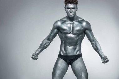 Acımasız güçlü kas vücut geliştirmeci atletik demir adam siyah arka plan üzerinde kasları pompalama. Egzersiz vücut geliştirme konsepti. Spor beslenme reklamları için kopya alanı.