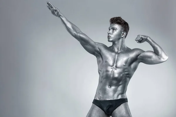 Brutal musclé musclé bodybuilder athlétique homme de fer pompage les muscles sur fond noir. Concept de musculation d'entraînement. Espace de copie pour les annonces de nutrition sportive . — Photo