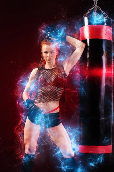 Mujer deportista boxeadora haciendo entrenamiento de boxeo en el gimnasio. Chica usando guantes, ropa deportiva sobre saco de boxeo. Motivación energética . — Foto de Stock