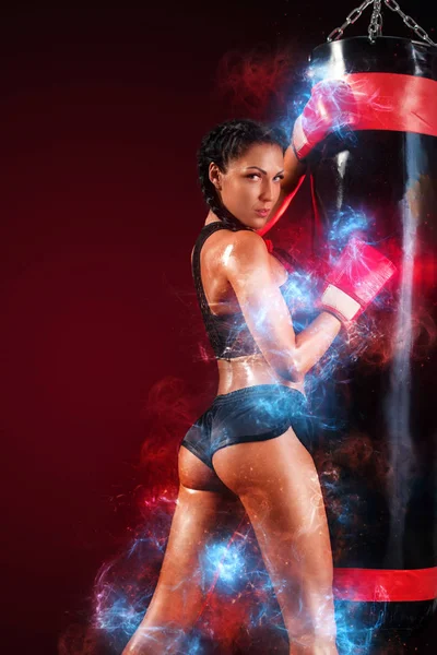 Mulher desportista boxeador fazendo treinamento de boxe no ginásio. Miúda com luvas, roupa desportiva sobre o saco de pancada. Motivação da aptidão energética . — Fotografia de Stock