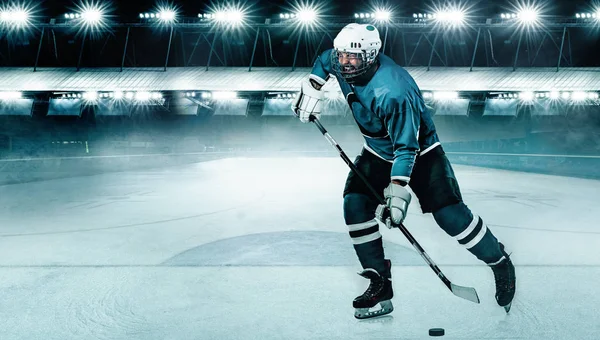 Giocatore di hockey su ghiaccio atleta nel casco e guanti sullo stadio con bastone. Un colpo d'azione. Concetto sportivo. — Foto Stock