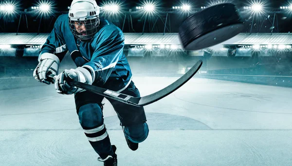 Ice Hockey player athlete in the helmet and gloves on stadium with stick. Action shot. Sport concept. — Stock Photo, Image