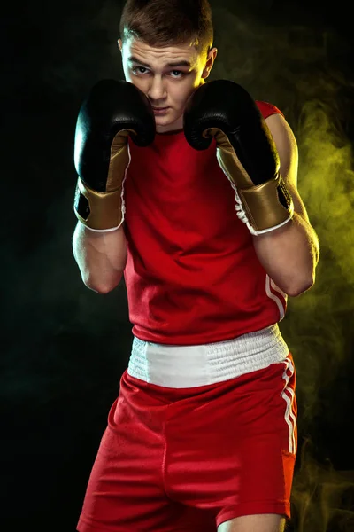 Sportsman, man boxare slåss i handskar. på svart bakgrund med färg rök. — Stockfoto