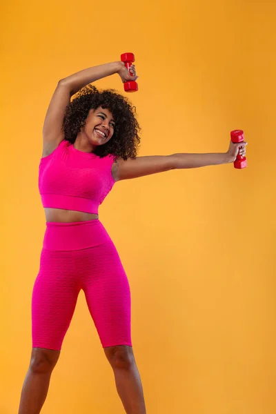 Mulher ajuste desportivo, atleta com halteres faz exercício de fitness no fundo branco. Aptidão e motivação laboral . — Fotografia de Stock