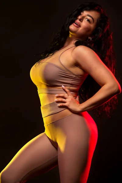 Jolie dodue, taille plus femme posant sur fond noir dans le gymnase de remise en forme . — Photo