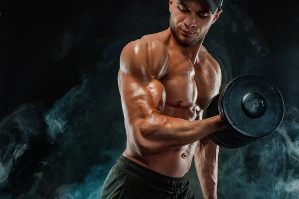 Мускулистый спортсмен, атлет с гантелями в тренажерном зале . — стоковое фото