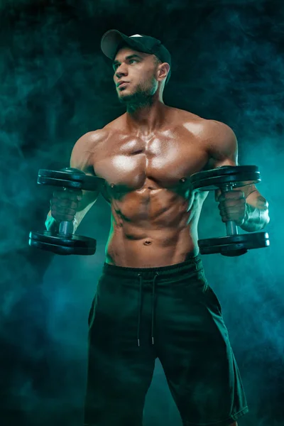 Muscular fitness sports man, atlete with dumbbell in fitness gym.