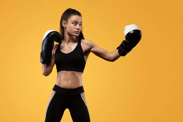 Sportsman, kvinna boxare slåss i handskar. på gul bakgrund. Boxning och Fitness koncept. — Stockfoto