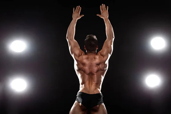 Starker muskulöser Bodybuilder Athlet, der auf schwarzem Hintergrund posiert und Muskeln aufpumpt. Trainingskonzept Bodybuilding. — Stockfoto