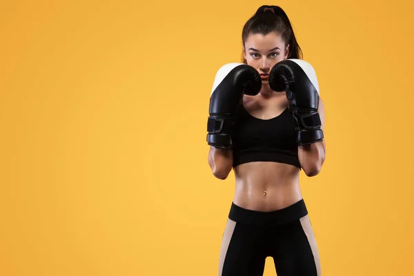 Deportista, boxeadora peleando con guantes. sobre fondo amarillo. Concepto de boxeo y fitness . — Foto de Stock