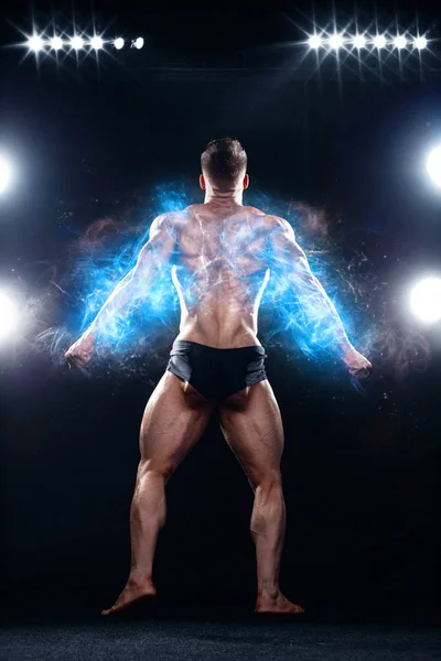 Sterke gespierde bodybuilder atleet man poseren en oppompen spieren op zwarte achtergrond. Training Bodybuilding concept. — Stockfoto